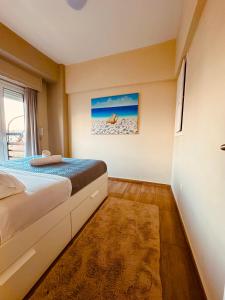 a bedroom with a bed and a picture of the beach at Blue Horizon Gem On The Port in Rafina