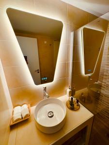 a bathroom with a sink and a large mirror at Blue Horizon Gem On The Port in Rafina +35 photos
