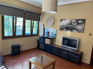 a living room with a tv and a clock on the wall at APARTAMENTO EN CANDAS in Candás