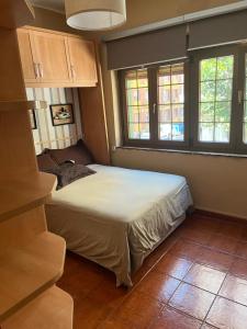 1 dormitorio con 1 cama y 2 ventanas en APARTAMENTO EN CANDAS, en Candás