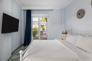 プラタモナスにあるVilla IOの白いベッドルーム(大型ベッド1台、窓付)