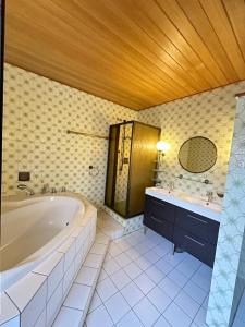 baño grande con bañera y lavamanos en Spacious Large apartment in Bielefeld en Bielefeld