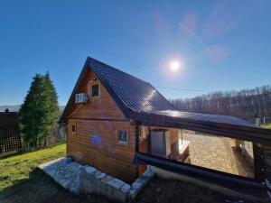 a wooden house with a roof on a field at Jerry's Cottage Banja Luka in Banja Luka