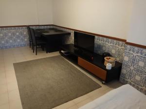 a living room with a tv and a dining table at Apartment 2BR in Queluz