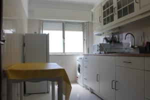 a kitchen with a refrigerator and a table in it at Apartment 2BR in Queluz