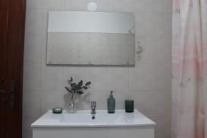 bagno con lavandino bianco e specchio di Apartment 2BR a Queluz