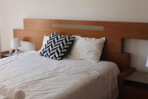 Una cama con dos almohadas encima. en Apartment 2BR, en Queluz