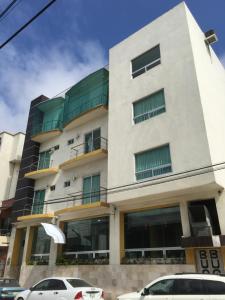 a building with cars parked in front of it at Hotel Empresarial in Paraíso