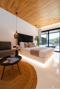 1 dormitorio con cama, mesa y sofá en Ftelia Black Villas, en Ftelia