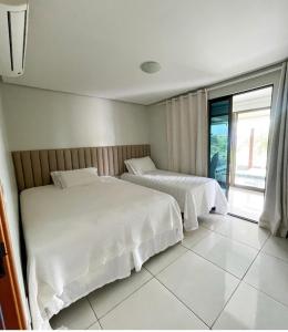 2 Betten in einem Hotelzimmer mit Fenster in der Unterkunft Flat bananeiras in Bananeiras