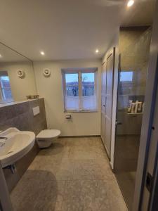 a bathroom with a sink and a toilet and a shower at Mölle Vattenmöllan in Mölle