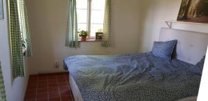 een slaapkamer met een bed met een blauw dekbed en een raam bij Mölle Vattenmöllan in Mölle