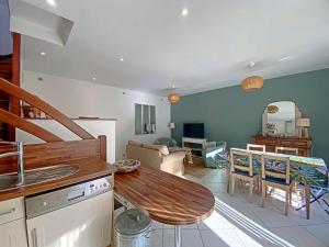 uma cozinha e sala de estar com uma mesa de madeira em RÉF 334 RIANTEC maison de pêcheur avec terrasse em Riantec