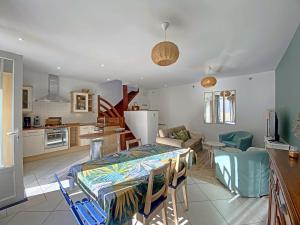 uma cozinha e sala de estar com uma mesa num quarto em RÉF 334 RIANTEC maison de pêcheur avec terrasse em Riantec