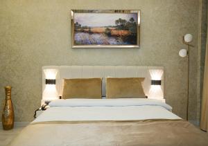 a bedroom with a bed with a painting above it at Luxury Medea Taksim Hotel in Istanbul