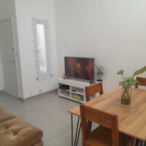 a living room with a table and a television at DPTO PLAZA GODOY CRUZ in Godoy Cruz