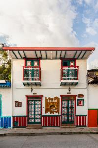 a building with red and white doors and windows at IntiLuna Hostel in Salento