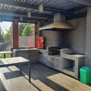 an outdoor kitchen with a grill and a stove at Departamento en Condominio privado Costa Pingueral in Concepción