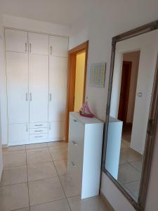 Habitación con armarios blancos y espejo. en Apartments Gracia & Toni, en Trogir