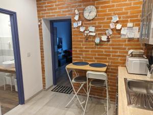 クーセグにあるVárfal apartmanのレンガの壁、テーブル、スツール付きのキッチン +5枚の写真