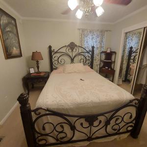 um quarto com uma cama e um lustre em Serenity Hill bed and Breakfast em Brownsville