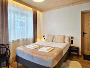 a bedroom with a bed with two towels on it at Willa Szyszka Zakopane in Zakopane