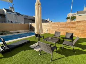 a group of chairs and an umbrella next to a pool at Valdevebas Chalet con Piscina in Madrid