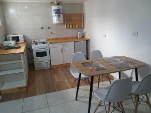 a small kitchen with a table and chairs in it at Departamentos calle 8 in Necochea