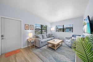 un salon avec un canapé et une table dans l'établissement Downtown Cottage - Walk to the Beach & Restaurants, à Cocoa Beach