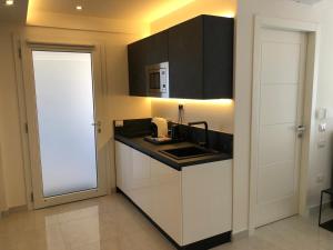 a kitchen with white cabinets and a black counter top at Residence Meridian Unità 7 in Villa San Pietro