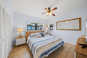 a bedroom with a bed and a ceiling fan at Downtown Cottage - Walk to the Beach & Restaurants in Cocoa Beach