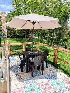 a table and chairs with an umbrella on a patio at Finca Villa Sophia! in Quimbaya