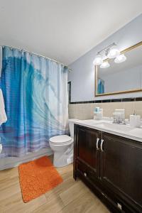 a bathroom with a sink toilet and a shower curtain at Downtown Cottage - Walk to the Beach & Restaurants in Cocoa Beach