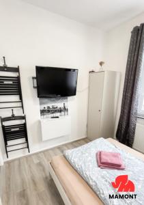 a bedroom with a flat screen tv on a wall at Schöne Monteurwohnung in Bremen-Gröpelingen in Bremen