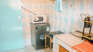 ナイロビにあるRebz'zeの冷蔵庫の上に電子レンジが備わる客室です。