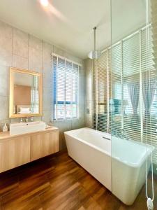 a bathroom with a tub and a sink and a mirror at Siri Oriental Bangkok Hotel - SHA Extra Plus in Bangkok