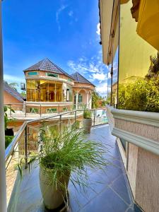 a house with potted plants on a balcony at The O.C Luxury Rooms in Kiembi Samaki