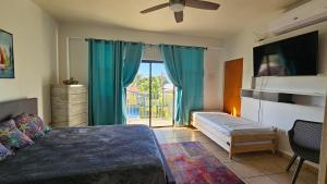 um quarto com uma cama e uma janela com cortinas azuis em Parguera Suites (Room), La Parguera, Lajas, PR em Lajas
