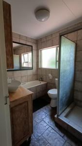 a bathroom with a tub and a toilet and a sink at 741 Tetra Self Catering Accommodation in Pretoria