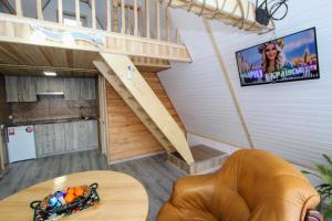 a living room with a spiral staircase and a table at Cottage "A-FRAME romantic house" in Yaremche
