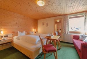 a bedroom with a large bed and a table and a couch at Haus Küng in Zürs am Arlberg