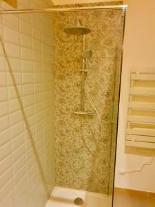 y baño con ducha y pared de azulejos. en Chambres d'Hôtes du Domaine de Bourbacoup en Tulle