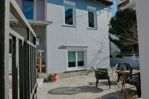 a patio with a chair and a table in front of a house at INOHO Moka Maisonette in Xanthi