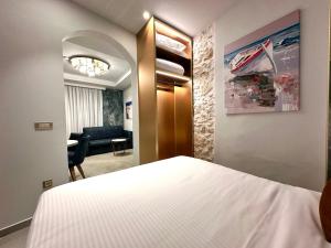 a bedroom with a bed and a living room at Royal Gold City Suites by Estia in Heraklio Town