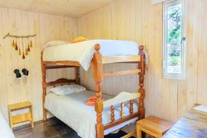 a bedroom with two bunk beds and a table at Glamping El Obrador Tilcara in Tilcara