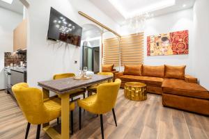 a living room with a table and chairs and a couch at Royal Gold City Suites by Estia in Heraklio Town