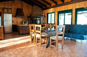 eine Küche mit einem Tisch und Stühlen sowie einem Kühlschrank in der Unterkunft Casa Rural La Laguna in Catral