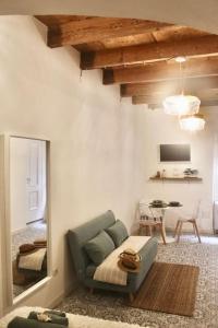 een woonkamer met een bank en een spiegel bij Casa Isabela in Alghero