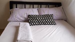a bed with two pillows and two towels on it at Mini Lookout Entebbe in Entebbe