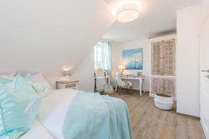 a bedroom with a bed and a desk and a table at Ostwestliebe in Zingst